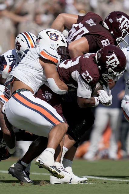 Auburn linebacker Elijah Melendez (9) stops Texas A&M running back Jamarion Morrow (23) afer a one yard gain during the first half of an NCAA college football game Saturday, Sept. 27, 2025, in College Station, Texas. (AP Photo/Sam Craft)