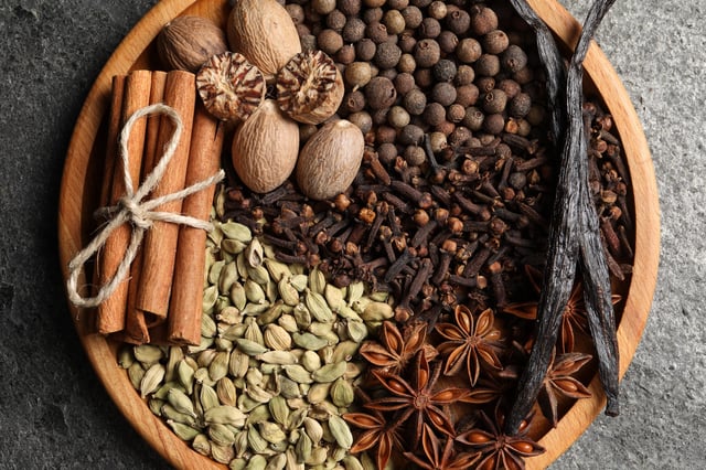 STOCK IMAGE: Different spices and nuts on gray table, top view