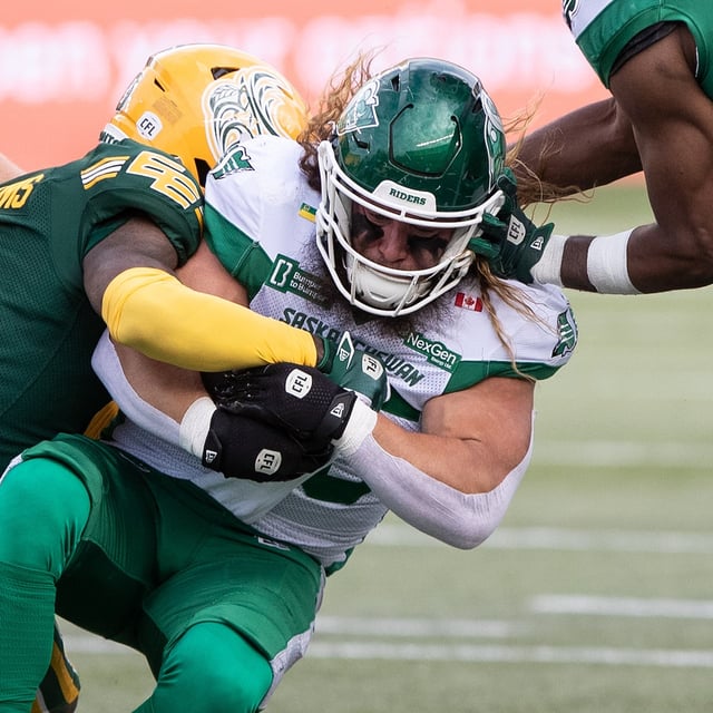 Saskatchewan Roughriders' A.J. Ouellette (right) is tackled by Edmonton Elks' Kobe Williams (0) during first half CFL action in Edmonton, on Saturday Sept. 27, 2025. THE CANADIAN PRESS/Jason Franson