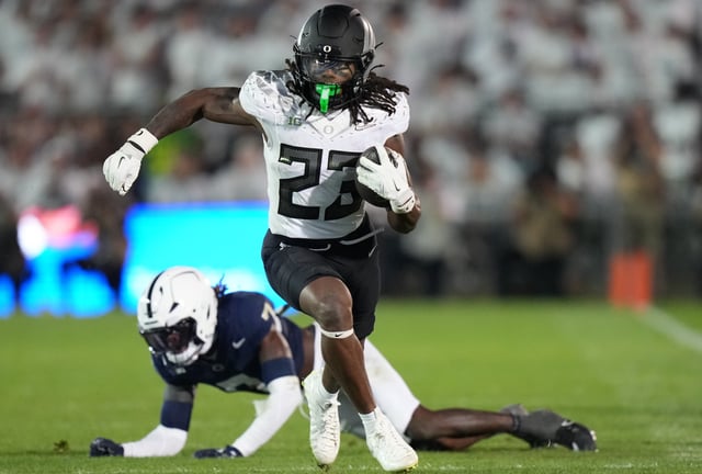 Oregon running back Dierre Hill Jr. (23) runs for a gain after breaking a tackle by Penn State cornerback Zion Tracy (7) during the third quarter at Beaver Stadium.