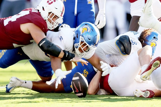 Stanford Cardinal’s Fisher Anderson (74) and San Jose State Spartans’ Gafa Faga (50) struggle for a fumble after Stanford Cardinal quarterback Ben Gulbranson (15) was sacked in the first half of a football game at Statanford Stadium in Stanford, Calif., on Saturday, Sept. 27, 2024. Faga recovered the fumble. (Ray Chavez/Bay Area News Group)