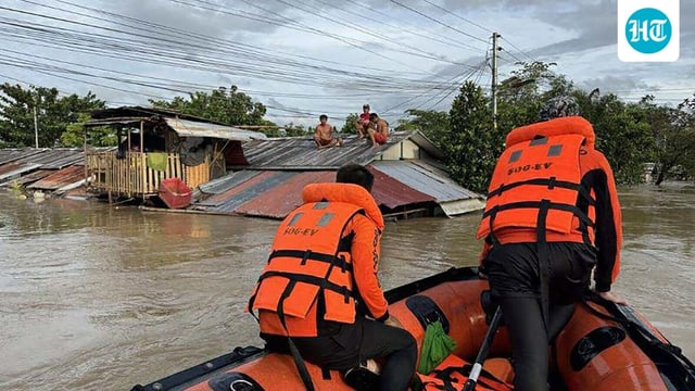 This handout photo taken on September 26, 2025 and released on September 27 by the Philippine Coast Guard shows coast guard personnel rescuing residents from their flooded house at the height of Severe Tropical Storm Bualoi, at a village in Ormoc City, Leyte province. 