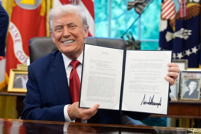 President Donald Trump holds a signed presidential memorandum on countering domestic terrorism and organized political violence, in the Oval Office at the White House, Thursday, Sept. 25, 2025, in Washington.