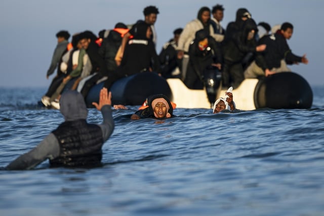 Des migrants tentent d'embarquer à bord d'un "small-boat" pour traverser la Manche le 27 septembre 2025 au large de la plage de Gravelines, dans le Nord