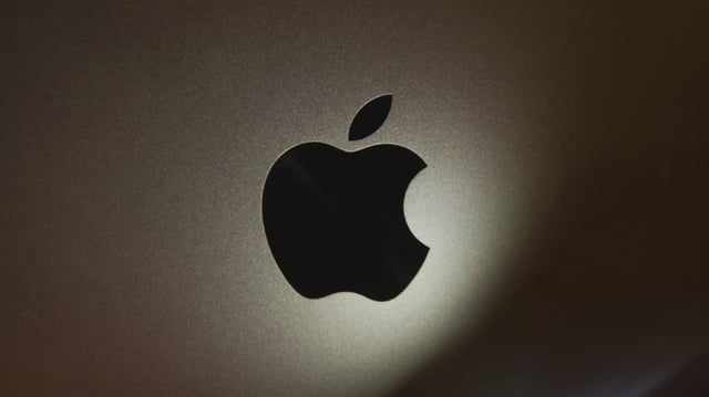 Black Apple logo on a metallic background
