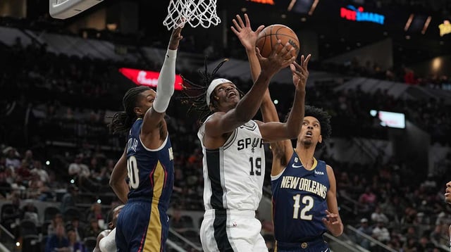 Oct 9, 2022; San Antonio, Texas, USA; San Antonio Spurs forward Alize Johnson (19) shoots in front of New Orleans Pelicans guard John Petty Jr. (30) and forward John Butler (12) in the second half at the AT&T Center. Mandatory Credit: Daniel Dunn-Imagn Images