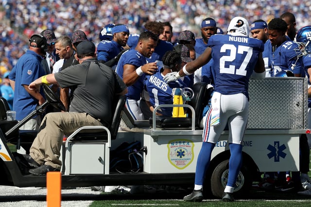 Teammates huddle around Malik Nabers #1 of the New York Giants who was injured on a play against the Los Angeles Chargers during the second quarter in the game at MetLife Stadium on September 28, 2025 in East Rutherford, New Jersey.