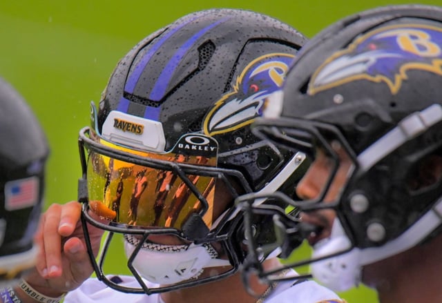 Standing with teammates, Baltimore Ravens wide receiver Tylan Wallace wipes rain drops from his visor during practice at Baltimore’s training facility for their upcoming NFL game hosted by the 1-2 Kansas City Chiefs. (Karl Merton Ferron/Staff)