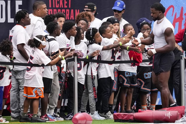Houston Texans linebacker Azeez Al-Shaair signs autographs for fans before an NFL football game against the Tennessee Titans at NRG Stadium in Houston, Sunday, Sept. 28, 2025.