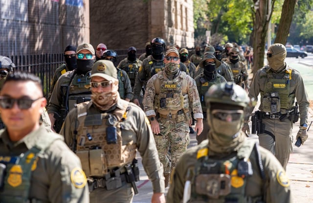 Federal agents march along North Clark Street by the Newberry Library in Chicago’s Gold Coast on Sept. 28, 2025, as part of an immigration blitz show of force. (Brian Cassella/Chicago Tribune)
