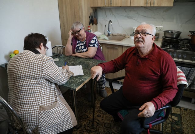People vote as members of a local electoral commission visit their home during Moldova's parliamentary elections in the town of Durlesti, Moldova September 28, 2025. REUTERS/Vladislav Culiomza