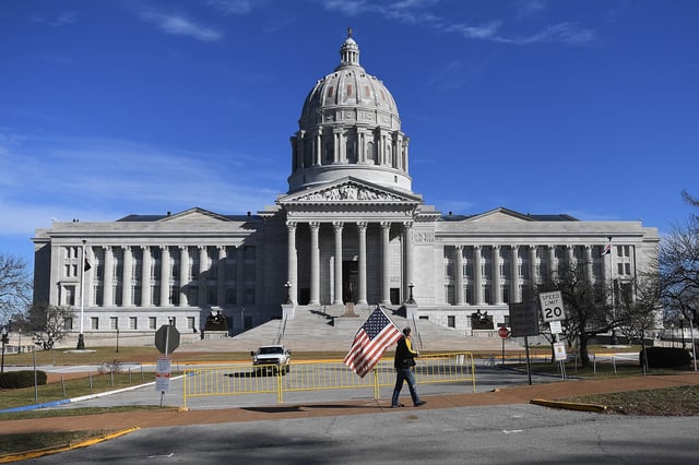 JEFFERSON CITY, MO - JANUARY 20: A man waves and American flag as he walks outside the Missouri State Capitol building on January 20, 2021 in Jefferson City, Missouri. Supporters of former President Donald Trump gathered at state capitol buildings nationwide today to protest the presidential election results and the inauguration of President Joe Biden as the 46th President of the United States.(Photo by Michael B. Thomas/Getty Images)