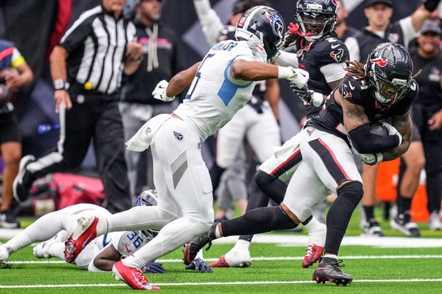 Houston Texans cornerback Derek Stingley Jr. (24) runs past Tennessee Titans wide receiver Elic Ayomanor (5) after intercepting a pass during the second half of an NFL football game at NRG Stadium in Houston, Sunday, Sept. 28, 2025.