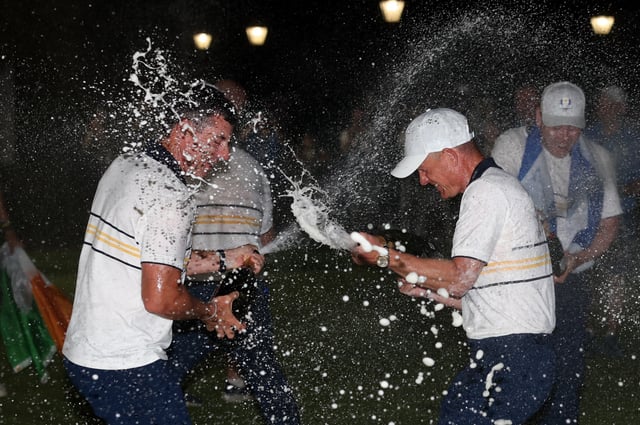Golf - The 2025 Ryder Cup - Bethpage Black Golf Course, Farmingdale, New York, United States - September 28, 2025 Team Europe captain Luke Donald and Team Europe's Rory McIlroy spray champagne as they celebrate winning the Ryder Cup REUTERS/Paul Childs