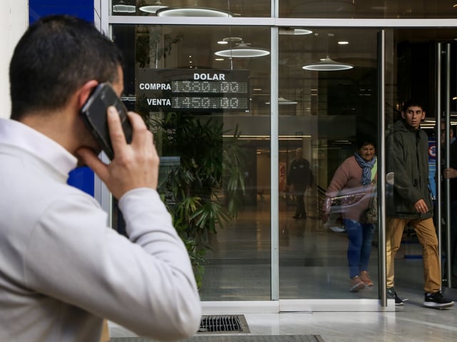 Un hombre habla por teléfono frente a cartel que menciona la cotización del dólar el 23 de Septiembre 2025. Foto/Antonio Becerra. - FTP CLARIN IMG_9564.jpg Z Invitado