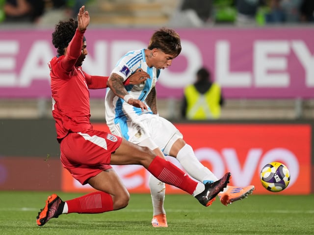 Argentina's Maher Carrizo connects a shot as Cuba's Camilo Pinillo attempts to block during a FIFA U-20 World Cup Group D soccer match at Elias Figueroa Brander Stadium in Valparaiso, Chile, Sunday, Sept. 28, 2025. (AP Photo/Andre Penner)