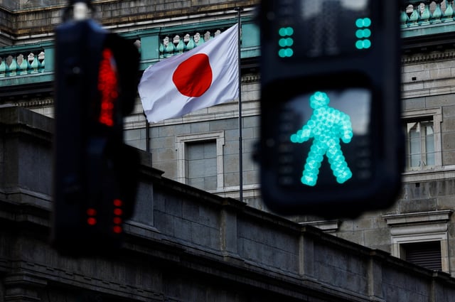 Japanese national flag hoisted atop the Bank of Japan headquarters building is seen between traffic signals in Tokyo, Japan, January 23, 2025.  REUTERS/Issei Kato/File Photo