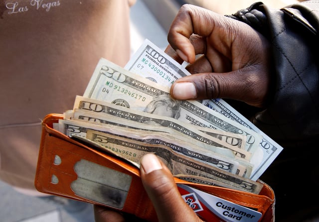 A man displays US dollar notes after withdrawing cash from a bank in Harare, Zimbabwe,  July 9, 2019. REUTERS/Philimon Bulawayo/File Photo