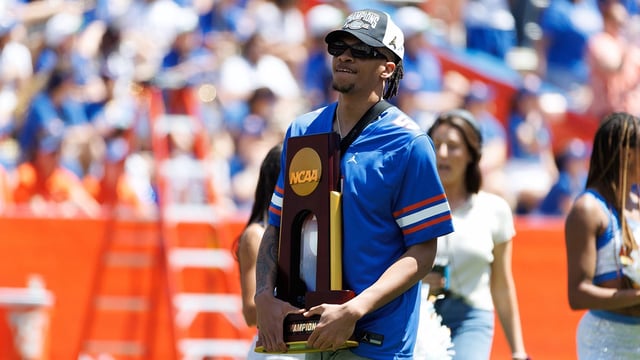 Apr 12, 2025; Gainesville, FL, USA; Florida Gators guard Will Richard (5) holds a trophy while walking onto the field during the National Championship celebration at Ben Hill Griffin Stadium. Mandatory Credit: Matt Pendleton-Imagn Images