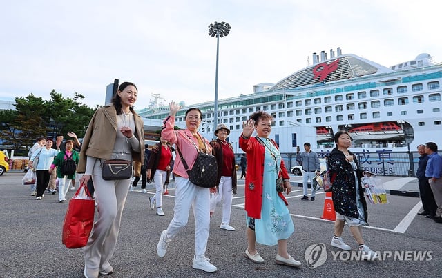 A group of Chinese tourists arrives by ferry at a cruise terminal in the port city of Incheon, west of Seoul, on Sept. 29, 2025, as a temporary visa waiver program for Chinese group tourists who visit South Korea began the same day, as part of efforts to boost the nation's tourism market. The program, which runs through June next year, allows more than three Chinese tourists on group tours to travel to South Korea without visas for as many as 15 days. (Yonhap)