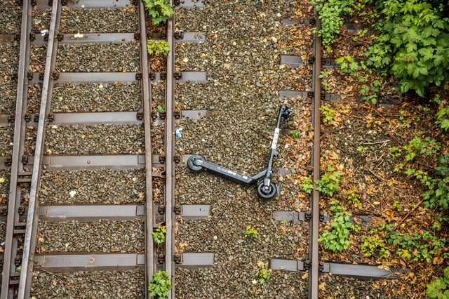 Ein E-Scooter liegt wischen zwei Bahngleisen (Symbolfoto).