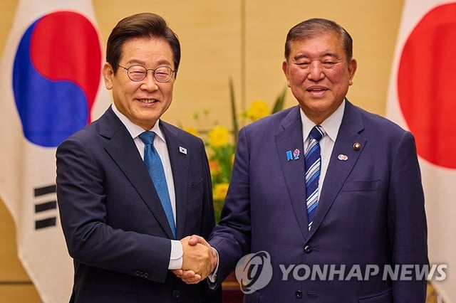 This Aug. 24, 2025, file photo shows President Lee Jae Myung (L) shaking hands with Japanese Prime Minister Shigeru Ishiba during their summit in Tokyo. (Yonhap)