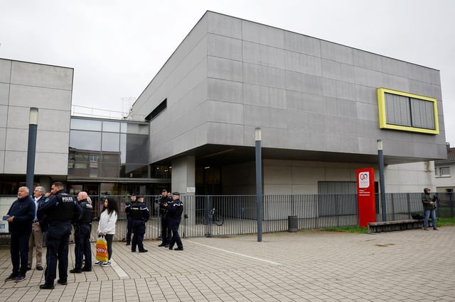 Des gendarmes et des policiers français se tiennent devant le collège Robert Schuman où un enseignant a été poignardé en classe par un élève de 14 ans, à Benfeld, près de Strasbourg, France, le 24 septembre