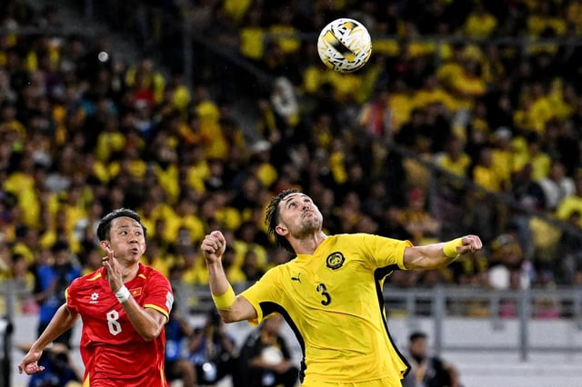 Vietnam’s Chau Ngoc Quang (left) fights for the ball with Malaysia’s Facundo Garces during an AFC Asian Cup qualifier match in June. Photo: AFP