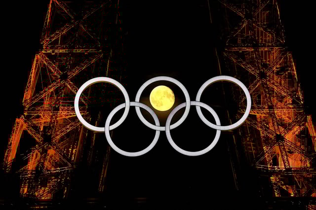The moon is pictured with the Olympic rings on the Eiffel Tower ahead the Paris 2024 Olympic and Paralympic Games in Paris, France, July 23, 2024.  REUTERS/Kai Pfaffenbach