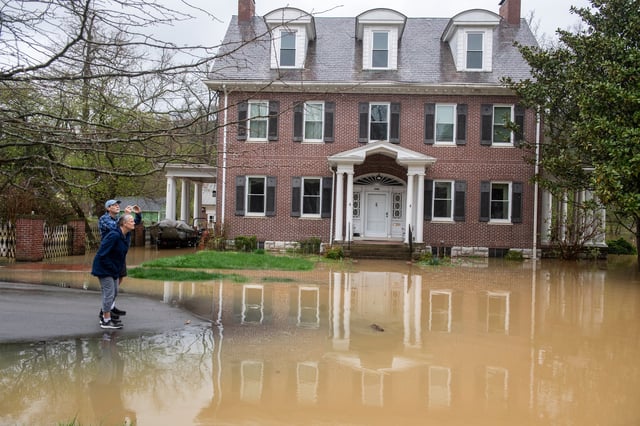 FRANKFORT, KENTUCKY - APRIL 6: Residents take pictures and videos in a neighborhood in Frankfort as The Kentucky River rises on April 6, 2025. Frankfort is expected to experience record flooding as the Kentucky River continues to rise. (Photo by Michael Swensen/Getty Images)