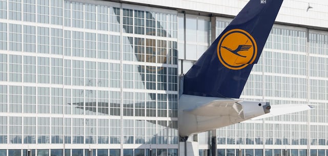 (FILES) The tale of a Lufthansa airplane sticks out of a hangar at the Franz Josef Strauss airport in Munich, southern Germany, on September 20, 2024. German airline group Lufthansa said on September 29, 2025 it will cut 4,000 jobs, nearly four percent of its workforce -- a move underscoring the slump gripping Europe's largest economy. Lufthansa said the majority of the job cuts would be in Germany and take place by 2030, targeting administrative rather than operational positions. (Photo by Michaela STACHE / AFP)