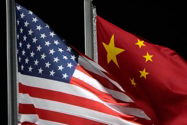 FILE - The American and Chinese flags wave at Genting Snow Park ahead of the 2022 Winter Olympics, Feb. 2, 2022, in Zhangjiakou, China. (AP Photo/Kiichiro Sato, File)