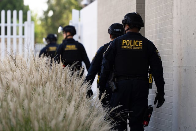Department of Homeland Security officials walk to the gates of the U.S. Immigration and Customs Enforcement facility after inspecting an area outside on Sunday, Sept. 28, 2025, in Portland, Ore.