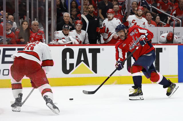May 15, 2025; Washington, District of Columbia, USA; Washington Capitals left wing Alex Ovechkin (8) shoots the puck as Carolina Hurricanes defenseman Sean Walker (26) defends in the third period in game five of the second round of the 2025 Stanley Cup Playoffs at Capital One Arena. Mandatory Credit: Geoff Burke-Imagn Images/ FIle Photo