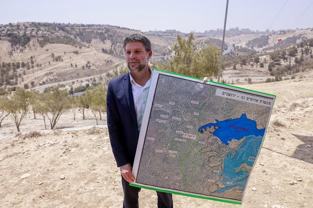 Bezalel Smotrich holds a map of one of the most controversial settlements in the West Bank — the E1 corridor — which splits the region in two