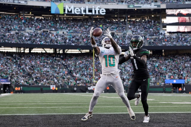 EAST RUTHERFORD, NEW JERSEY - NOVEMBER 24: Tyreek Hill #10 of the Miami Dolphins fails to catch a touchdown pass against Sauce Gardner #1 of the New York Jets during the first quarter in the game at MetLife Stadium on November 24, 2023 in East Rutherford, New Jersey. (Photo by Rich Schultz/Getty Images)