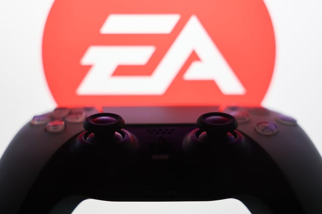 Electronic Arts logo displayed on a laptop screen and DualSense controller are seen in this illustration photo taken in Krakow, Poland on September 29, 2025. (Photo by Jakub Porzycki/NurPhoto)