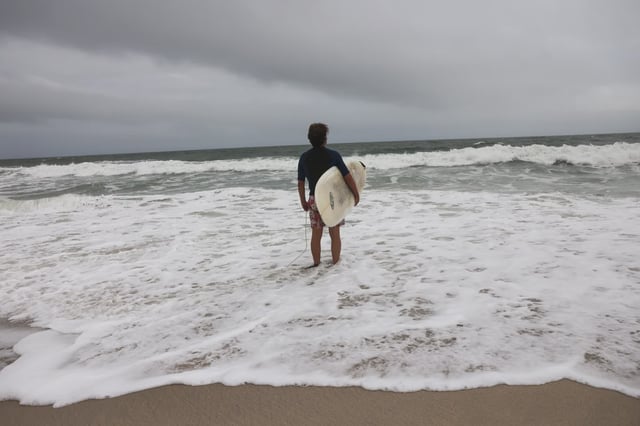 A surfer prepares to go into the ocean on a beach closed in August due to strong riptides in Surf City, Long Beach Island, New Jersey. Tropical Storm Imelda and Hurricane Humberto could pose rip current risks for the area this week.