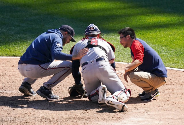 CHICAGO, ILLINOIS - MAY 13: Manager Rocco Baldelli #5 of the Minnesota Twins and a team trainer check on Mitch Garver #8 during a game against the Chicago White Sox at Guaranteed Rate Field on May 13, 2021 in Chicago, Illinois. (Photo by Nuccio DiNuzzo/Getty Images)