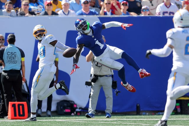 Sep 28, 2025; East Rutherford, New Jersey, USA; Los Angeles Chargers cornerback Cam Hart (20) breaks up a pass intended for New York Giants wide receiver Malik Nabers (1) during the second quarter at MetLife Stadium. Nabers was carted off the field with an injury after the play. Mandatory Credit: Brad Penner-Imagn Images