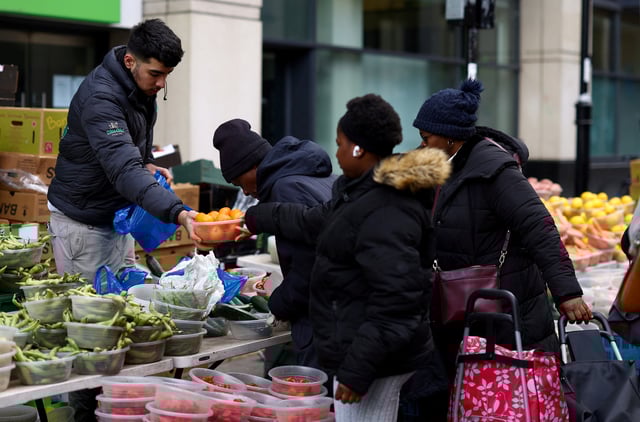 Customers buy fresh produce from a fruit and vegetable stall on Surrey Street market in Croydon, south London, Britain, February 26, 2024. REUTERS/Hannah McKay