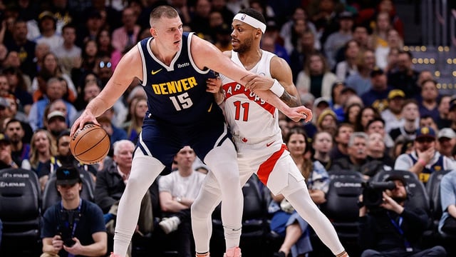 Mar 11, 2024; Denver, Colorado, USA; Denver Nuggets center Nikola Jokic (15) controls the ball as Toronto Raptors forward Bruce Brown (11) guards in the second quarter at Ball Arena. Mandatory Credit: Isaiah J. Downing-Imagn Images