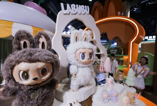 An employee gestures next to Labubu toys on display at Pop Mart’s booth at China International Fair for Trade in Services (CIFTIS) in Beijing, China, September 10, 2025. REUTERS/Maxim Shemetov