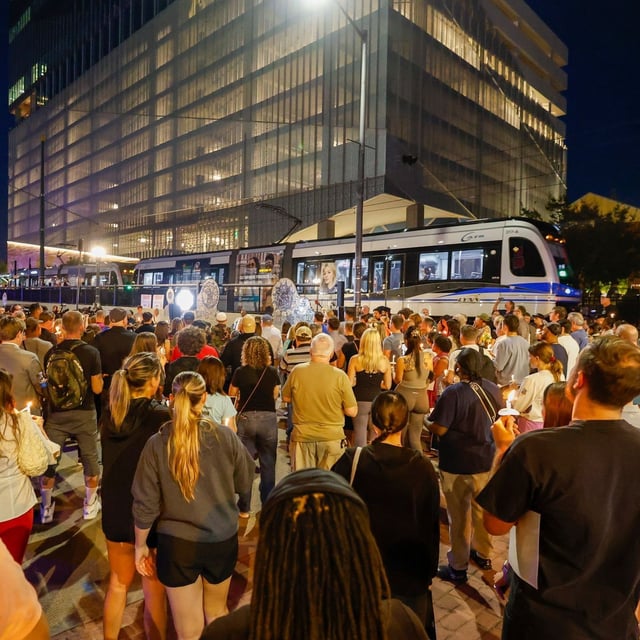 A light rail train passes by as community members gather for a vigil honoring the life of Iryna Zarutska, who was fatally stabbed on a commuter train last month, Monday, Sept. 22, 2025, in Charlotte, N.C. (AP Photo/Nell Redmond)