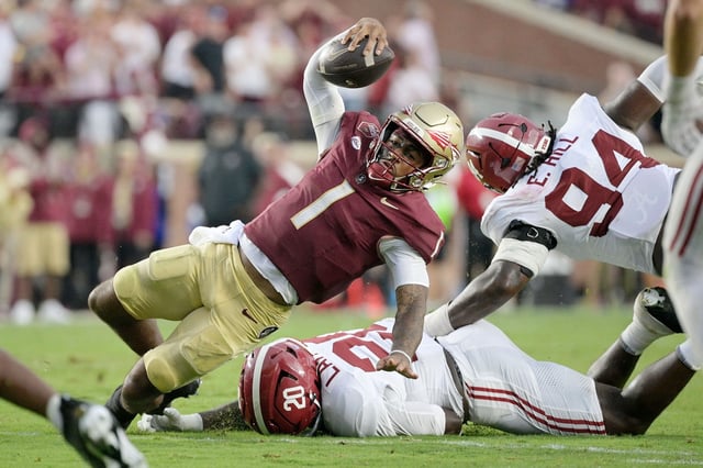 Aug 30, 2025; Tallahassee, Florida, USA; Florida State Seminoles quarterback Tommy Castellanos (1) loses his footing against Alabama Crimson Tide linebacker Jah-Marien Latham (20) during the second half at Doak S. Campbell Stadium. Mandatory Credit: Melina Myers-Imagn Images