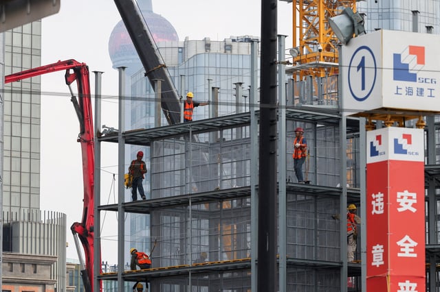 Construction workers operate on a construction site in Shanghai, China, July 10, 2025.  REUTERS/Go Nakamura/File Photo