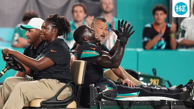 Miami Dolphins wide receiver Tyreek Hill, right font, puts his arms up as he is carted off the field after suffering an unknown lower leg injury in the second half of an NFL football game against the New York Jets, Monday, Sept. 29, 2025, in Miami Gardens, Florida.