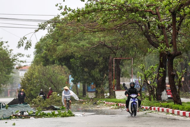 People commute on a partially flooded street after Typhoon Bualoi makes landfall in Nghe An province, Vietnam, September 29, 2025. REUTERS/Thinh Nguyen