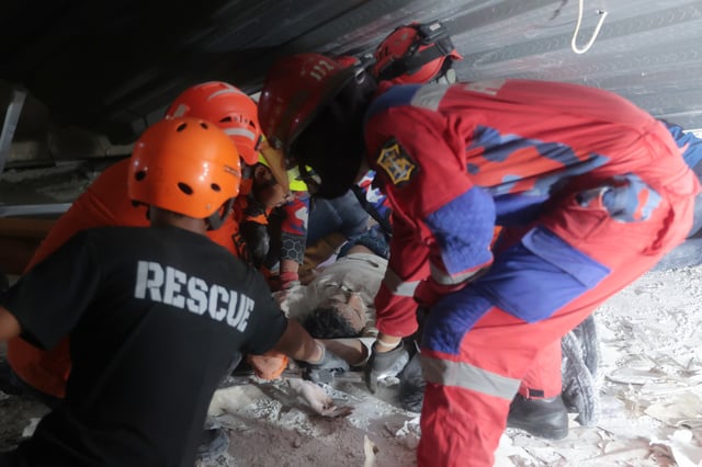 Rescuers pull out a survivor from a collapsed building at an Islamic boarding school in Sidoarjo, East Java, Indonesia, Monday, Sept. 29, 2025. (AP Photo/Trisnadi)