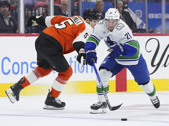  Nils Hoglander controls the puck against Egor Zamula of the Philadelphia Flyers on October 19, 2024 in Philadelphia, Pennsylvania.